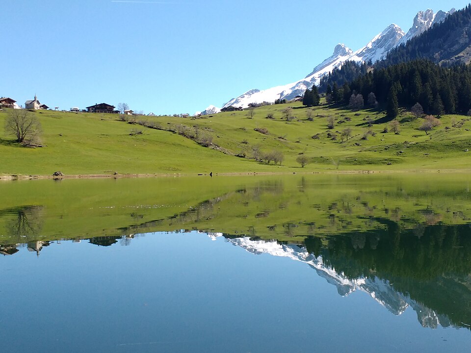 Le lac des Confins au printemps, avec de la neige sur les reliefs.